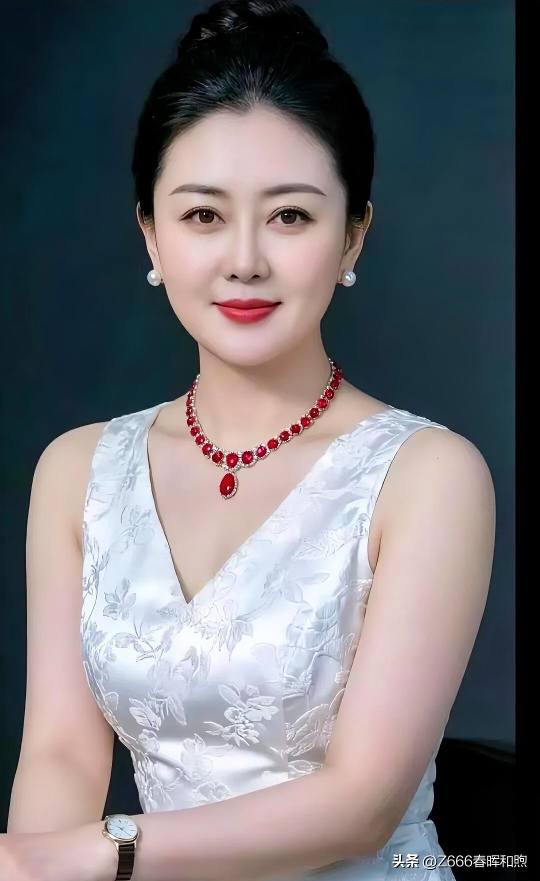 素衣绣花凝雅韵，红宝流光映玉颜。珠辉腕底藏温婉，一笑倾城胜春山。