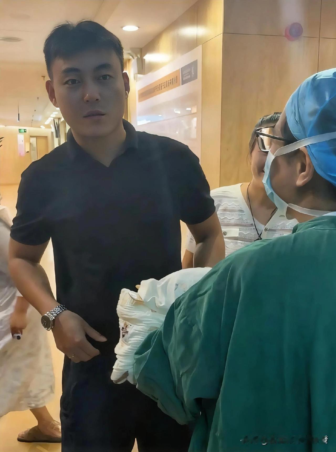 护士抱着刚出生的宝宝从产房里出来，见到孩子爸爸后，护士让他猜猜是男孩还是女孩，爸