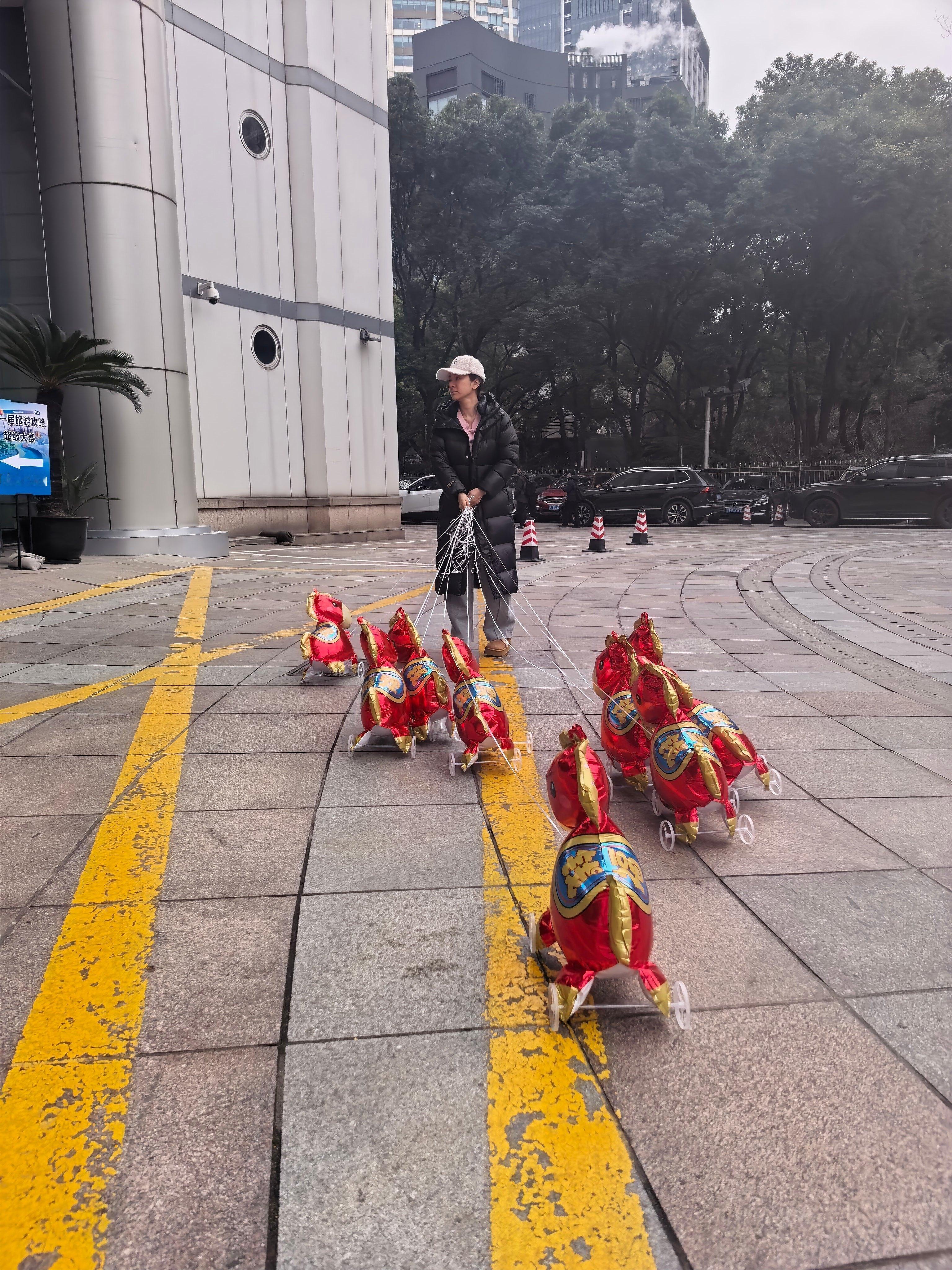 黄奕牵着9匹气球马上班上班路瞬间变成新年许愿池！黄奕牵着的每匹气球马都像一枚浮动