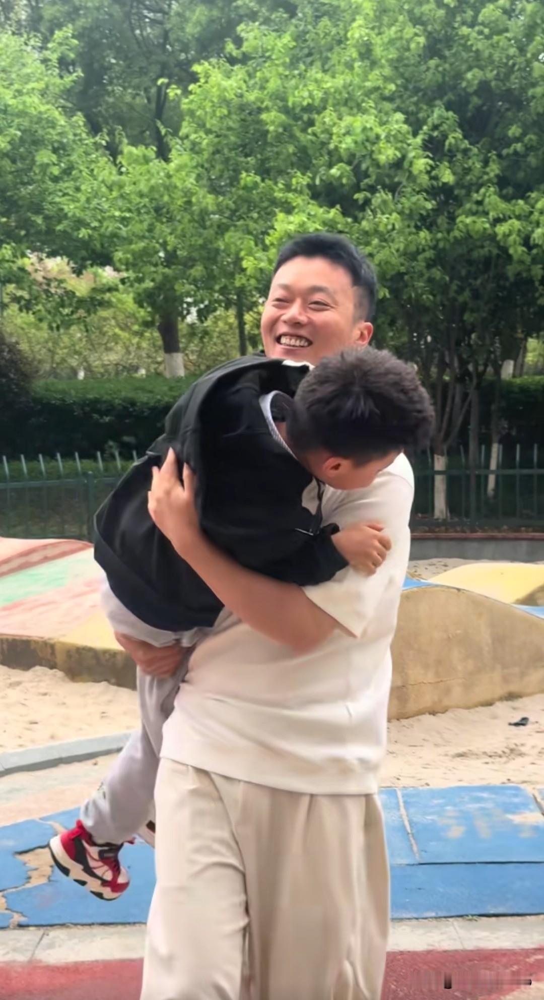 在公园的小天地里，秋天爸爸和儿子手牵手，踩着欢快的节奏跳着舞。爸爸先脱下外套，小