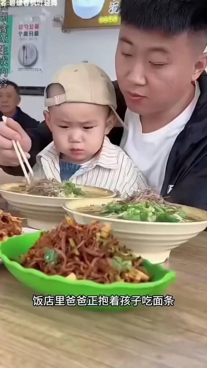 饭店里爸爸正抱着孩子吃面条，爷爷推门走了进来。小家伙一看竟然是爷爷，立刻从爸爸怀