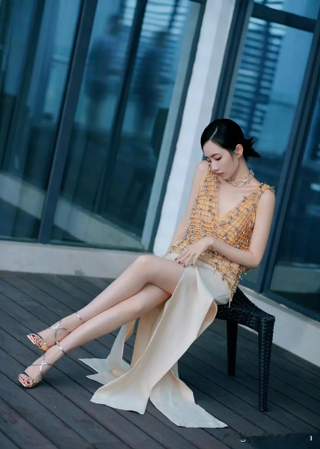 刘惜君优雅坐椅间，金色与米白交织的时尚穿搭，尽显都市女性魅力