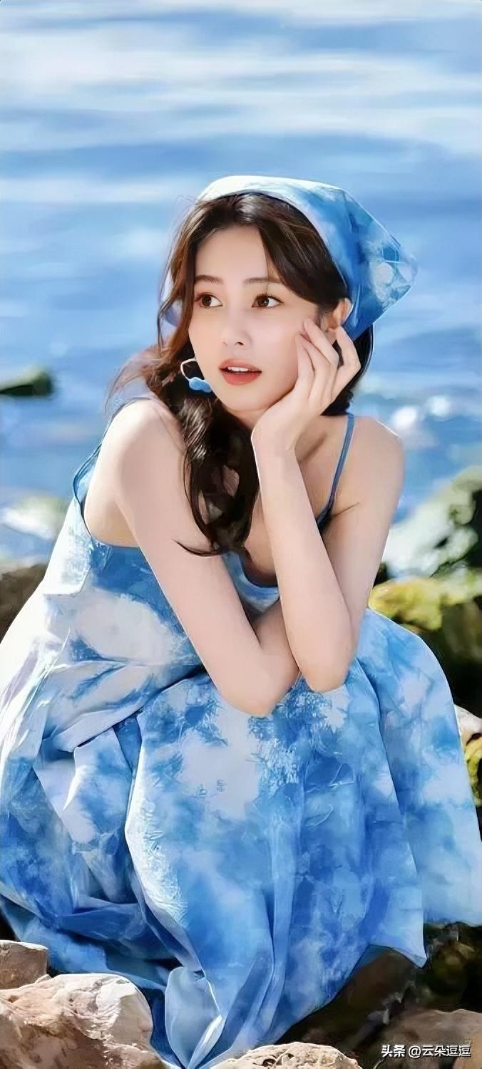 海边少女，蓝裙飘逸，海风吹拂，梦幻如画。