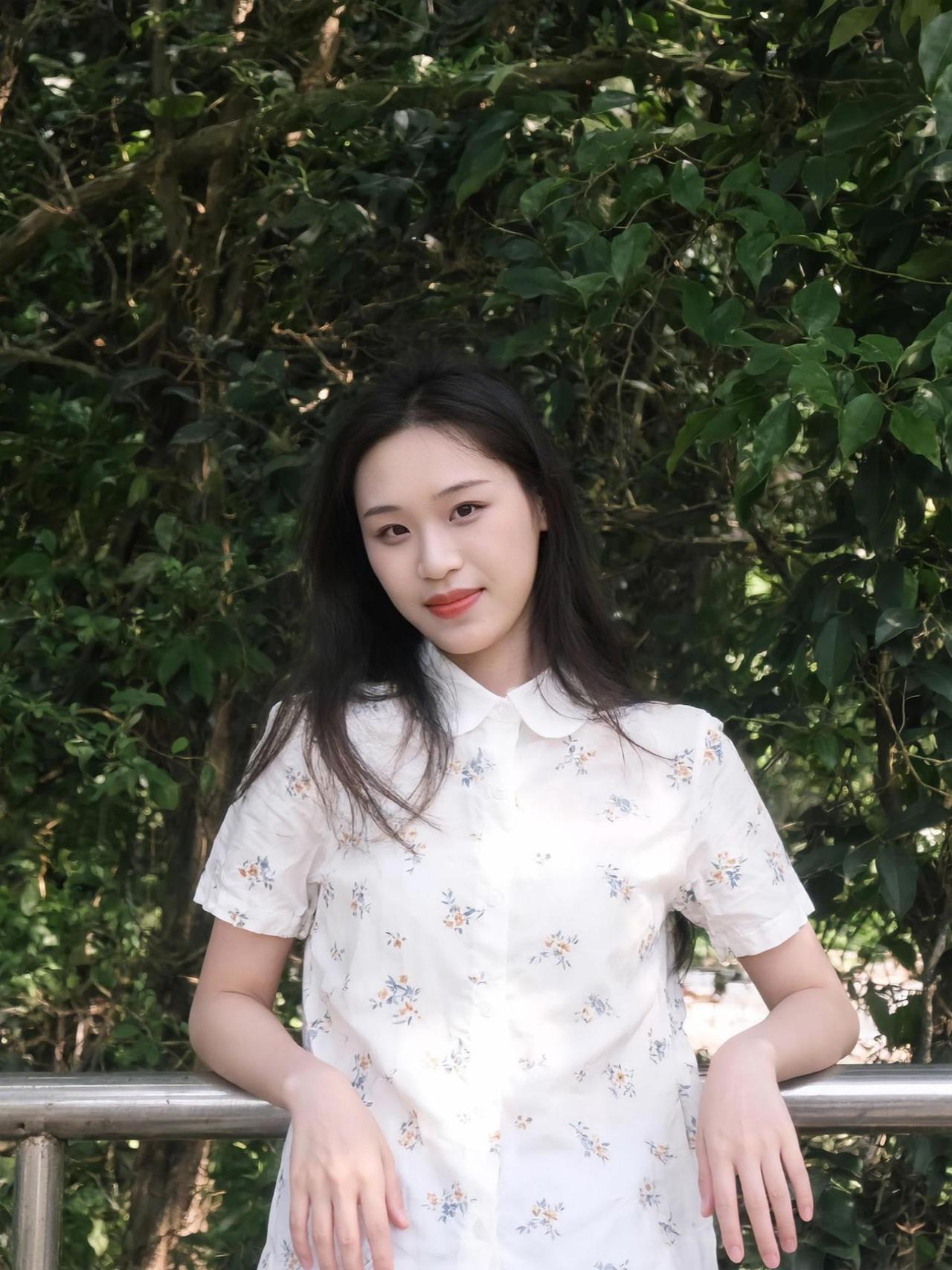 在绿意盎然的背景下，一件白衬衫如同画布上的一抹纯净，点缀着细碎的花朵，仿佛是大自