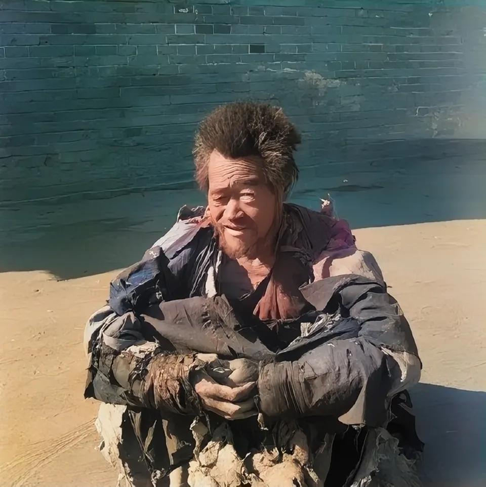 1920年，北平街头，一名乞丐坐在地上，等待着好心人的施舍，照片中的他衣衫褴褛，