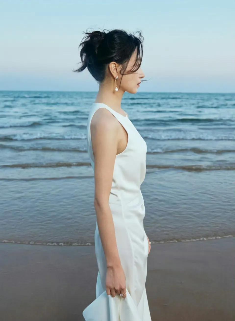 站在海边的她，认真看向远方，蔚蓝色的大海为背景，世界仿佛只剩下了她自己！这个角度