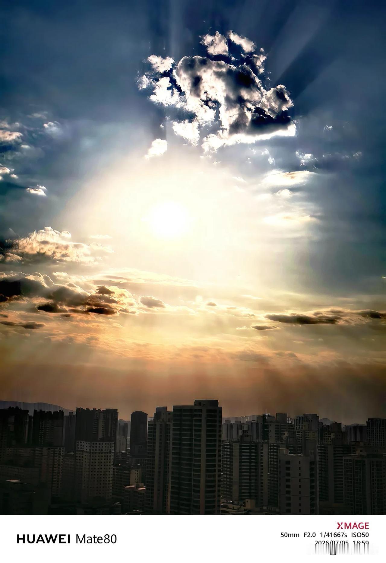 夕阳收尽最后一缕炽光，天光由金橙渐转为清透深蓝，一束耶稣光穿透层云，斜洒在城市楼