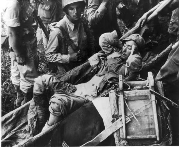 1944年，中国西南地区，一名受伤的国军士兵被抬上一艘渡船，送往由美军医疗队设立