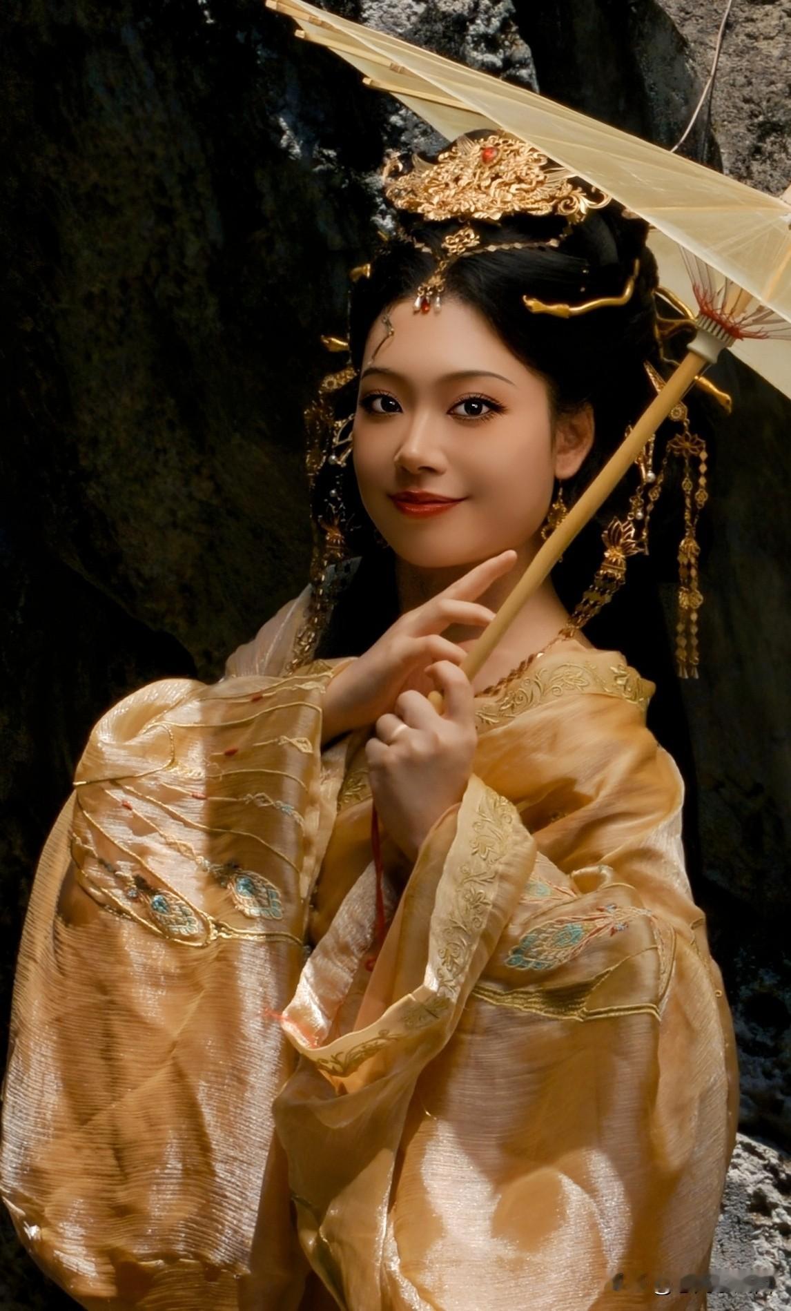 山涧仙姿，宛如盛唐之景
   鎏金美服映照山涧微光，她手持伞儿伫立，衣袂上的凤纹