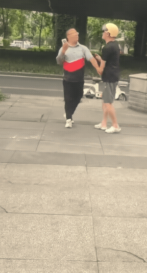 穿黑服的好像还是个老外，看了原视频是黑衣服的动手在先的！还好有大妈给拉住了及时收