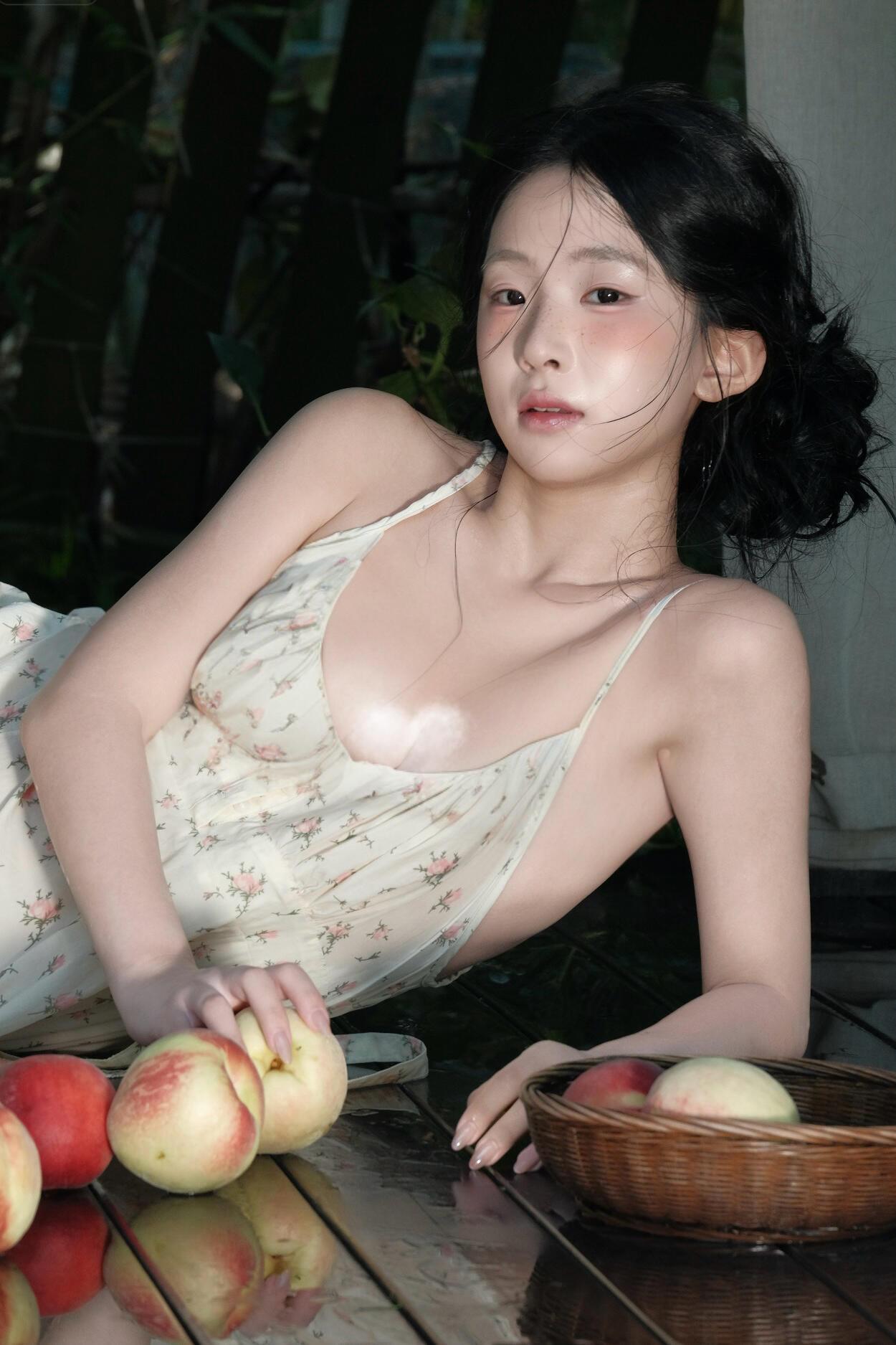 照片的复古感绝了，像从旧画报里走出来的画面。碎花吊带裙、饱满的水蜜桃，再加上林间