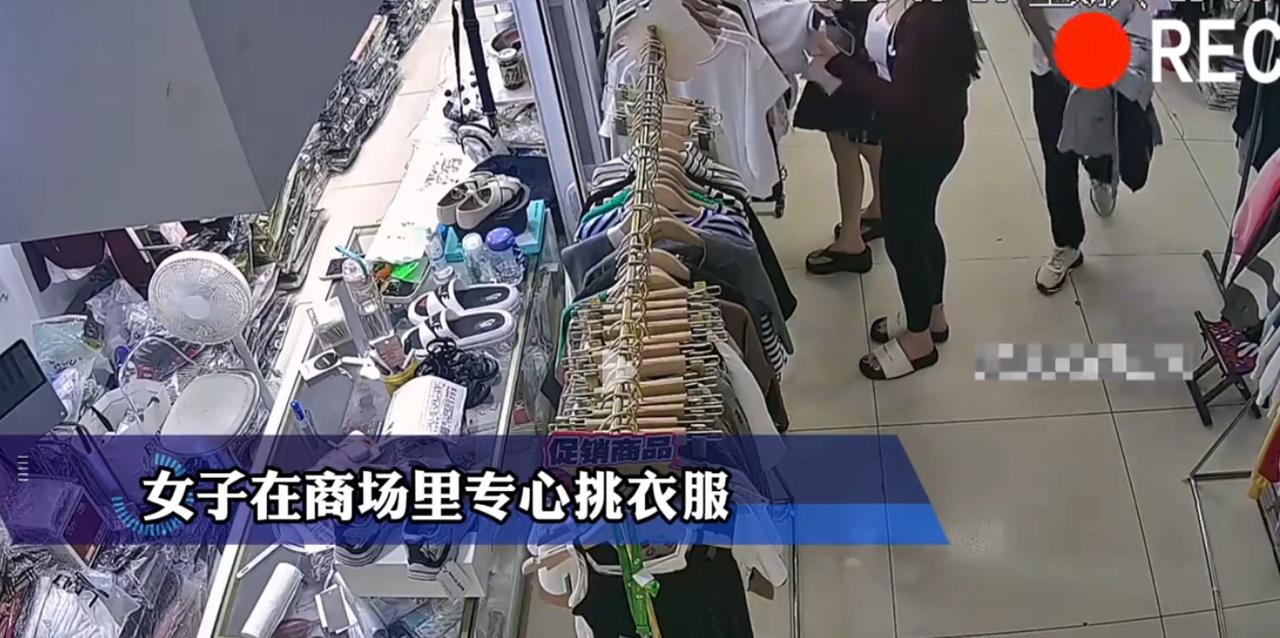 “太炸裂了！”商场里一名女子正在挑选衣服，这时身后路过一名男子，只见他遮挡住自己