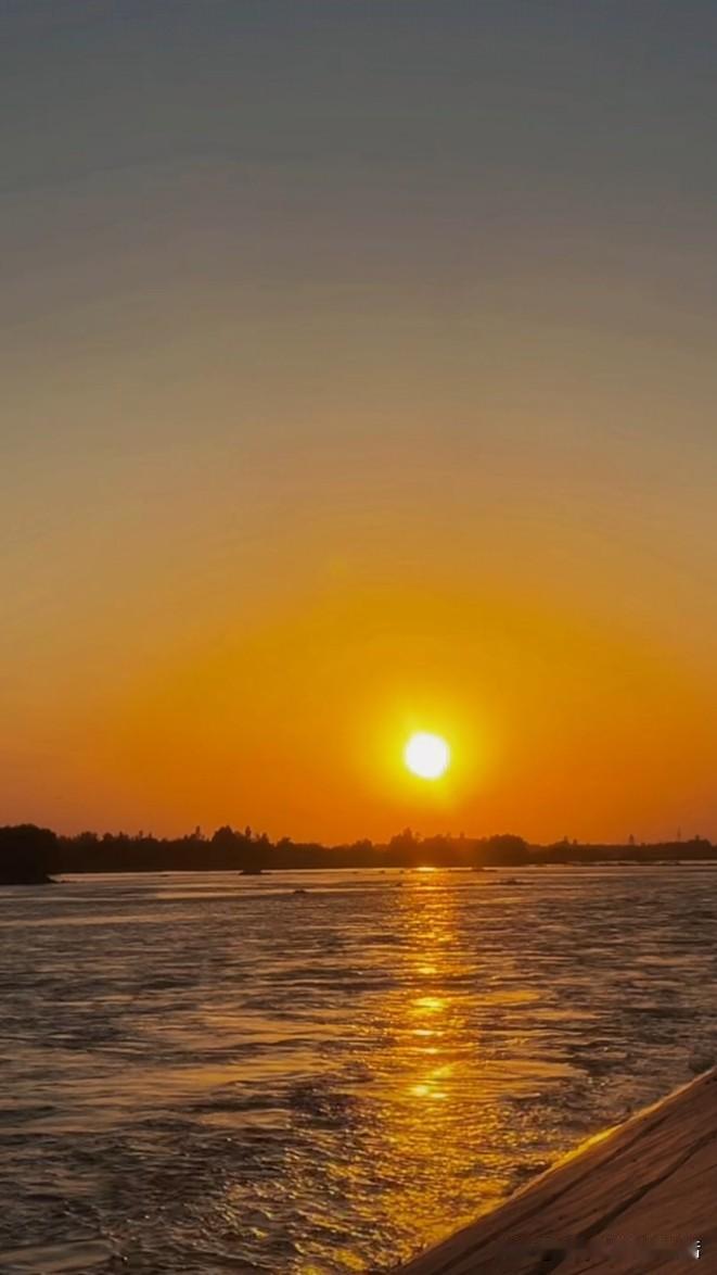 夕阳西下归港的渔船挂满浑身发光的碎夕阳，船桨划开的水痕闪着星星点点的暖光，把整片