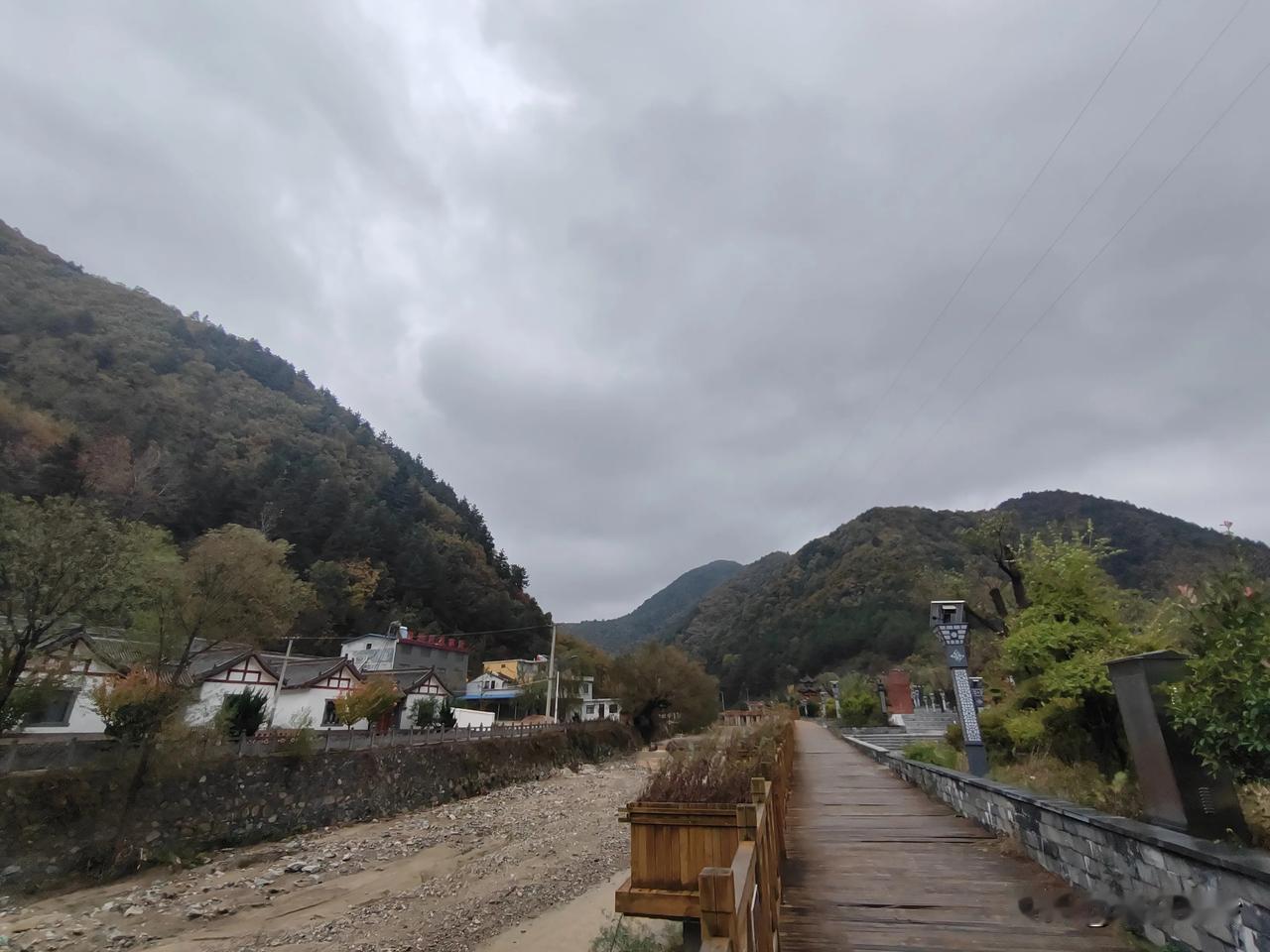 
        走过木栈道，两旁是石墙，中间是河道，远处青山环绕，近处民居隐现