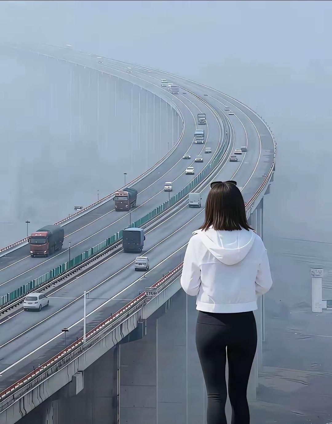 美女高架桥旁站，
很多车辆开上边。
天空弥漫厚浓雾，
对岸人儿看不见。