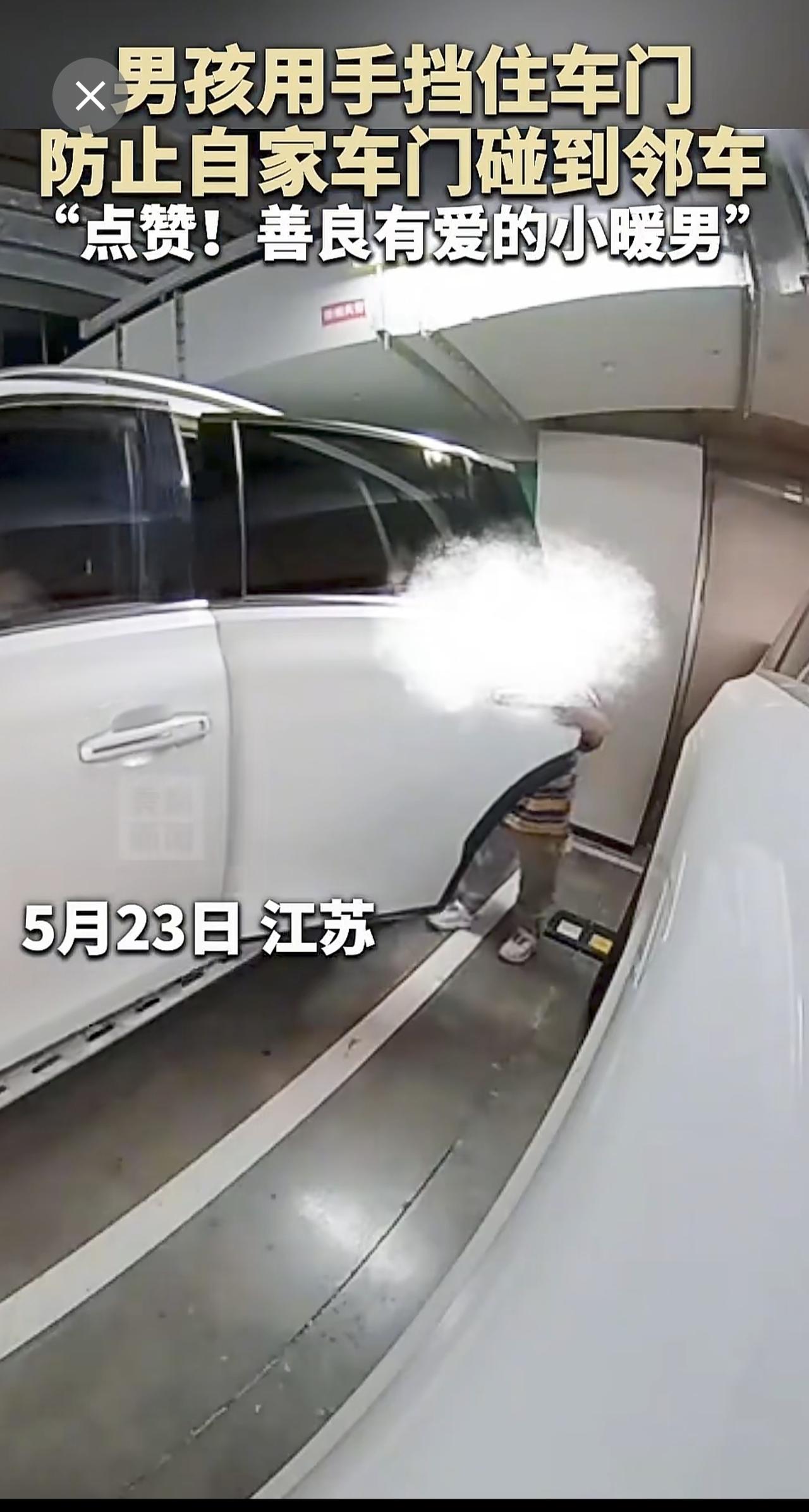 5月23日，江苏，男孩用手挡住车门，防止自家车门碰到邻车。“点赞！善良有爱的小暖