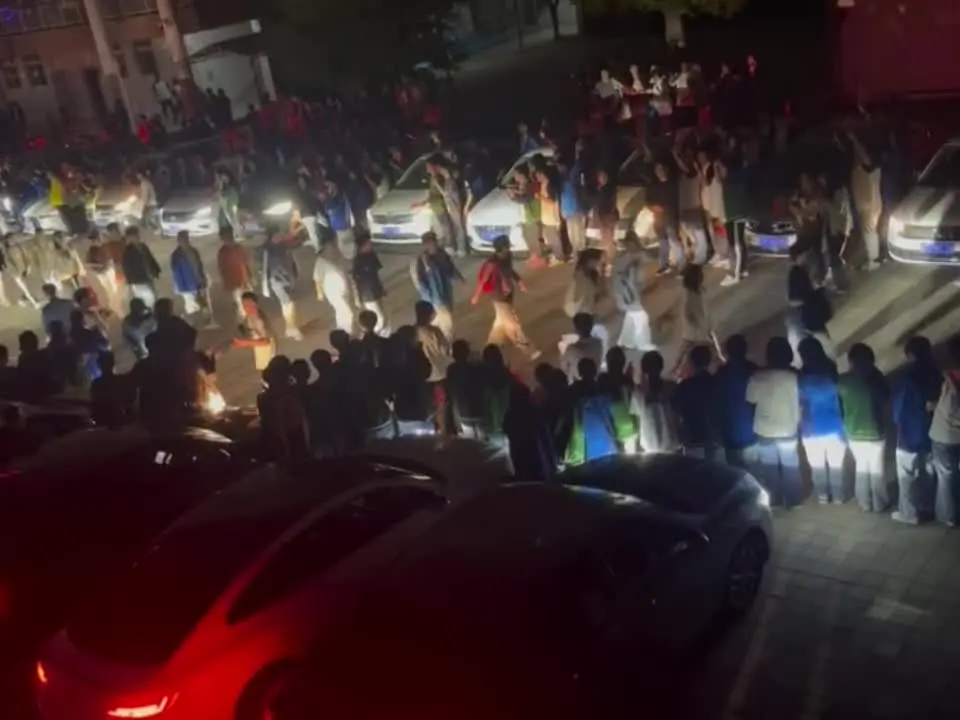 高考前的晚上 全校老师打开车灯 为我们照亮前方的路 寓意照亮前程