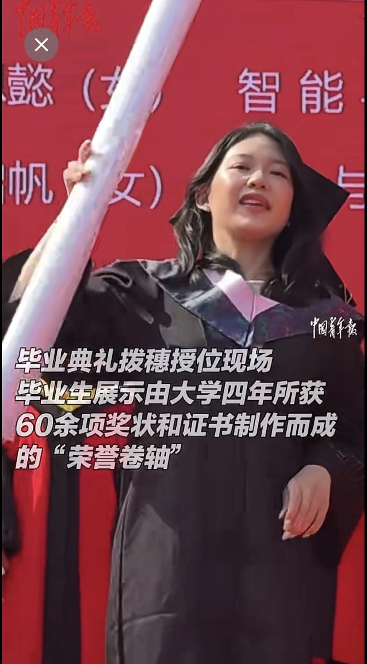 毕业生在毕业典礼的拨穗授位现场，展示“荣誉卷轴”。（中国青年报、沈阳城市学院）