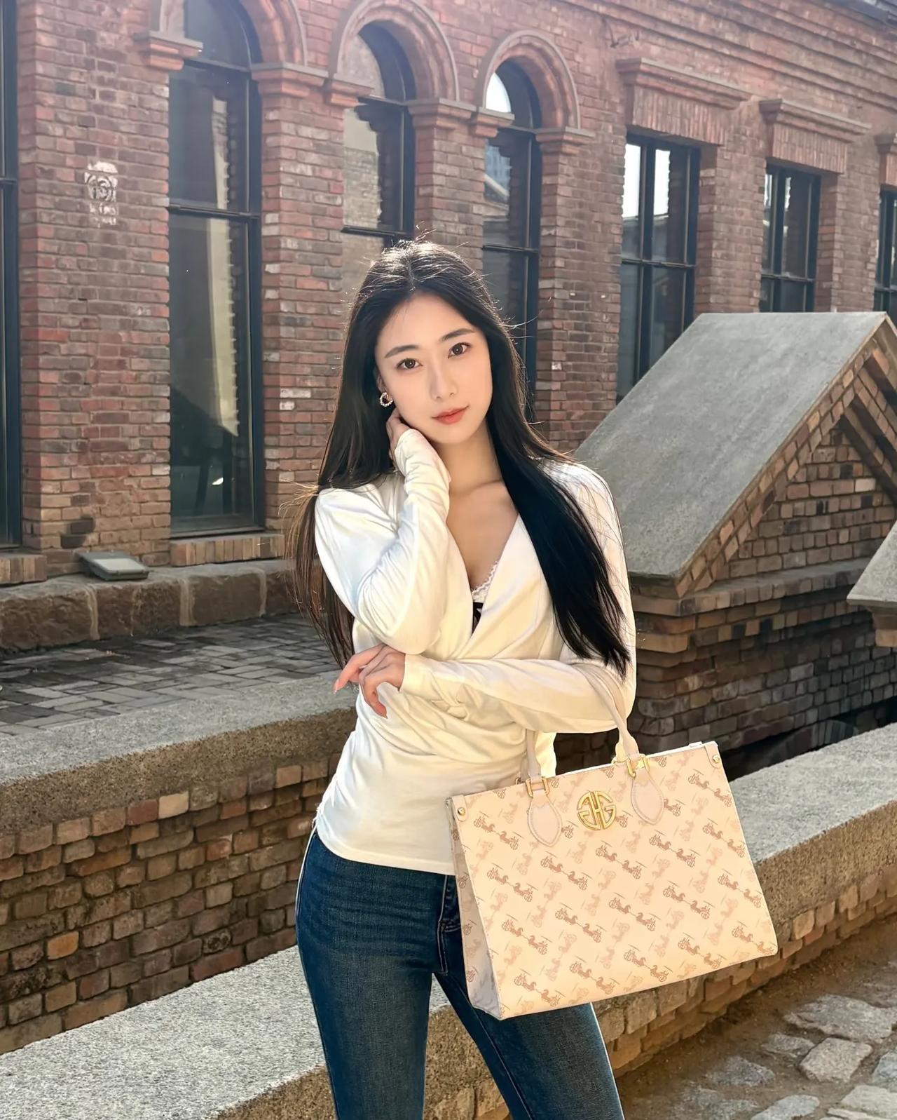 优雅白衬衫搭配复古砖墙，时尚手袋点缀，都市风范十足！