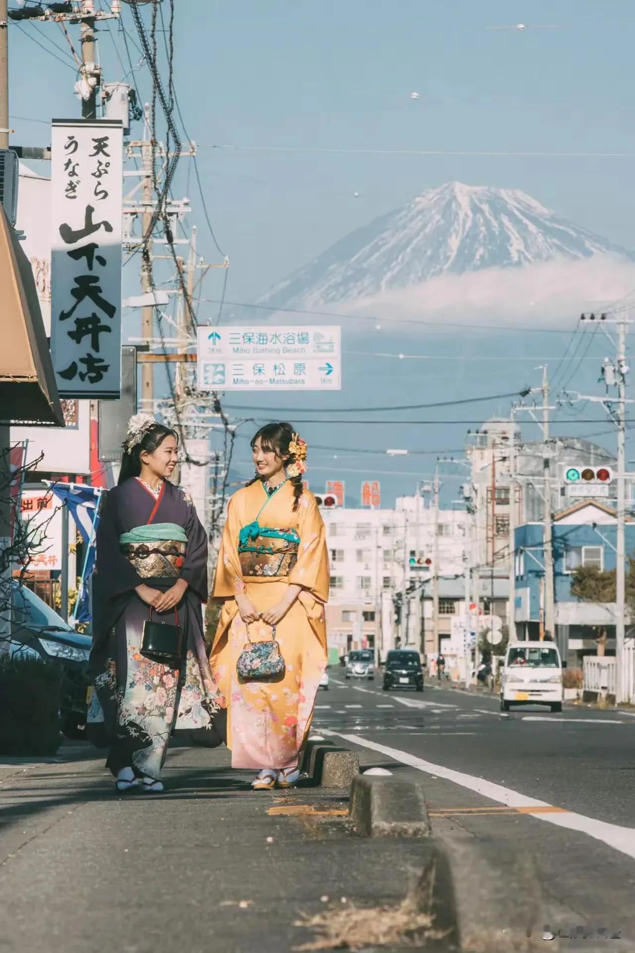 日本的两个美少女在富士山下的大街中悠悠转动，身穿和服，笑容可掬。让人看啦，觉得可