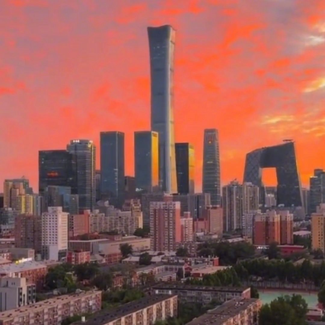 夜晚坐在国贸旁的咖啡馆外，玻璃幕墙将霓虹映成流动的光，掌心裹着热饮的暖意。身边年