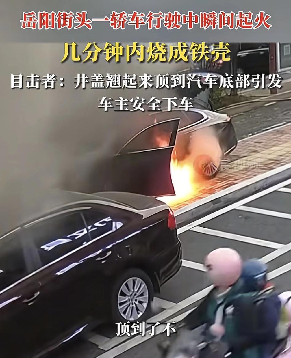 湖南岳阳一辆小车在行驶过程中突然着火，目击者称其因是因为车底刮蹭到了路边的井盖，