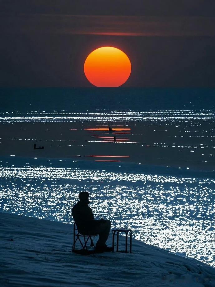 落日垂落海平面，余晖浸染万顷碧波。静坐海边，听潮起潮落，跟着海浪缓缓呼吸。晚风裹