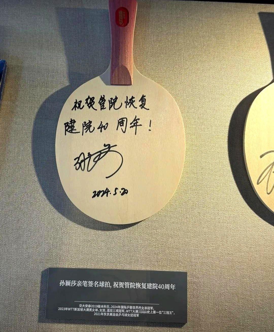 这是豆包给自己母校，上海交大管理学院的签名球拍。

有眼尖的网友发现"建"字写得