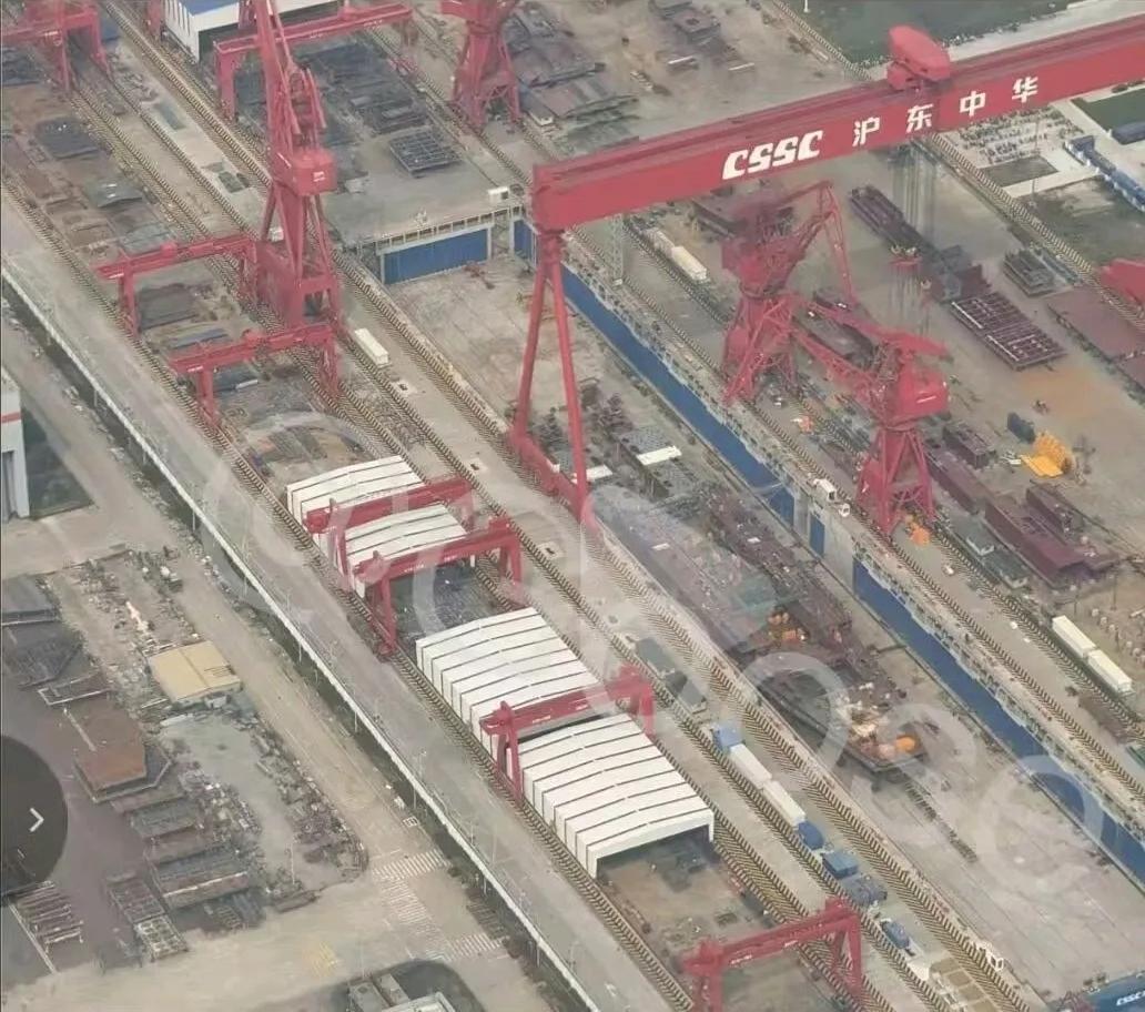 沪东中华造船厂的一座干船坞内，出现了一艘正处于模块化组装阶段的两栖攻击舰，其外形
