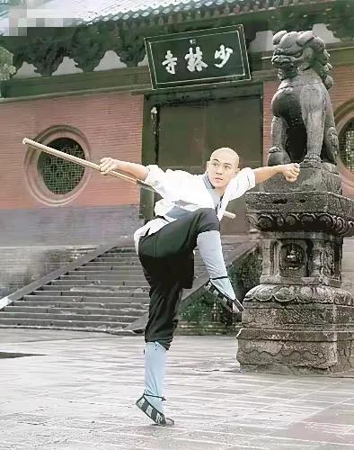 李连杰当年最经典的一张照片。
在古寺庭院中，一僧人正专注演练传统武术，棍影翻飞，