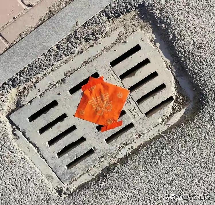 出门发现，邻居蹲在小区路上，把红纸一张张往井盖上糊。

二十多个，一个不能落。