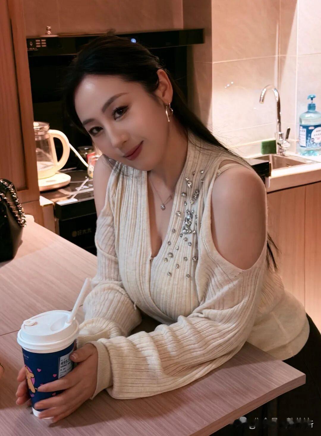 暖棕调厨房漫着温柔，针织衫的钻芒与纸杯的蓝，把片刻松弛酿成了闪光的诗。

珍珠耳