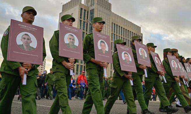 古巴哈瓦那街头，军人们手捧着32名在委内瑞拉献身的士兵遗像，供民众致敬。古巴领袖