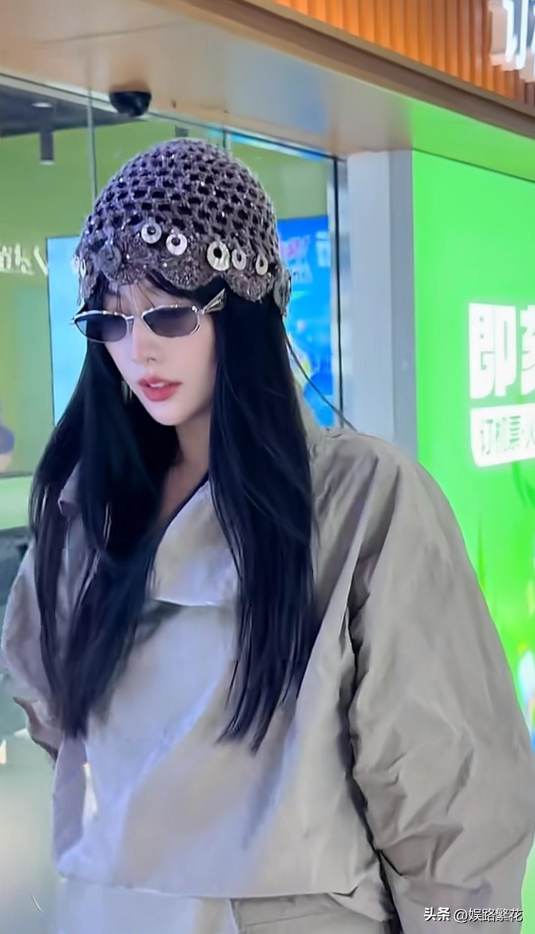 张嘉倪现身机场，她现在好漂亮啊！头戴着镂空亮片针织包头帽，巴掌大小的瓜子脸，五官