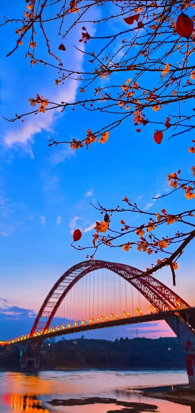 黄昏时分，红桥倒映在河面上，秋叶点缀其间，美不胜收。