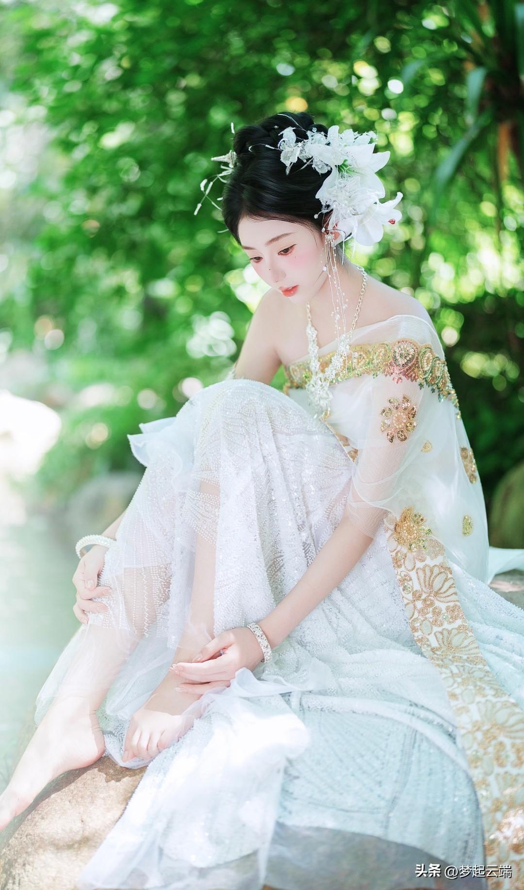 梦幻傣家少女✨，花间静坐，裙摆飘逸，宛如仙子下凡。