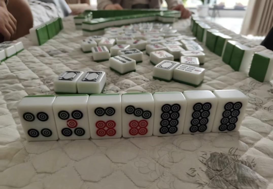 一桌人正在玩四川麻将。看这牌应该胡哪一张？