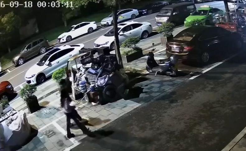 9月18日凌晨 重庆，一对情侣在路上行走，男子突然一脚猛踹路边停放的电动车，车子直接倒地，男子踹完转