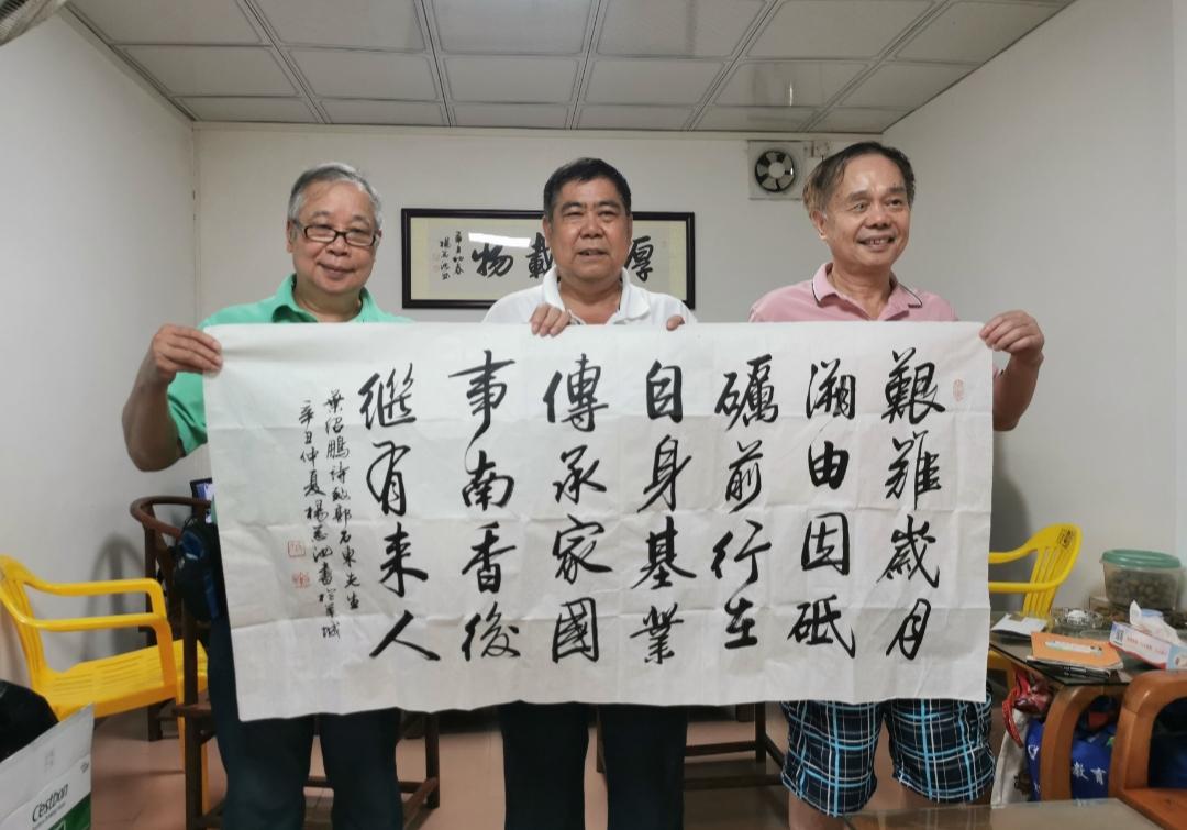 书写广州诗人叶绍鹏(图右)诗，为广州增城新塘郭村老书记郭石东(图中)居家补壁。