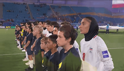 看到伊朗女足在奏国歌是沉默不语，主教练甚至露出一种诡异的笑容，这不禁让人想起20