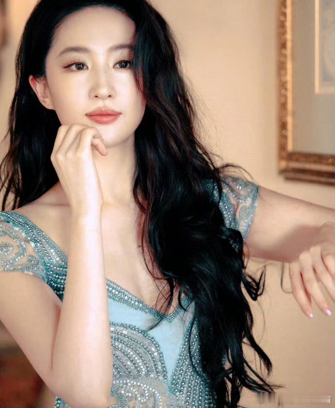 刘亦菲身着冰蓝色重工钉珠薄纱长裙，清透的色彩与她白皙肤色相映成趣，薄纱轻盈朦胧，