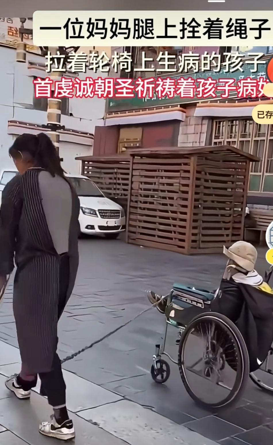 一位妈妈腿上拴着绳子，拉着轮椅上生病的孩子，以无比虔诚的姿态朝圣，一心祈祷孩子能
