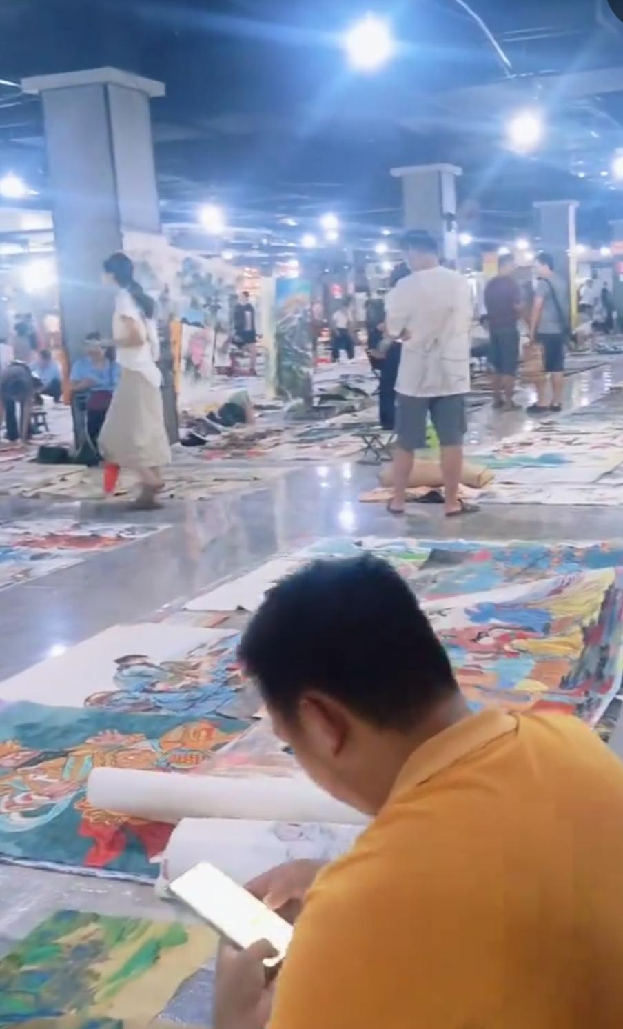 不知道网友拍在哪的书画市场，人来人往，相当的热闹又冷清。说他热闹，无数的人来到这