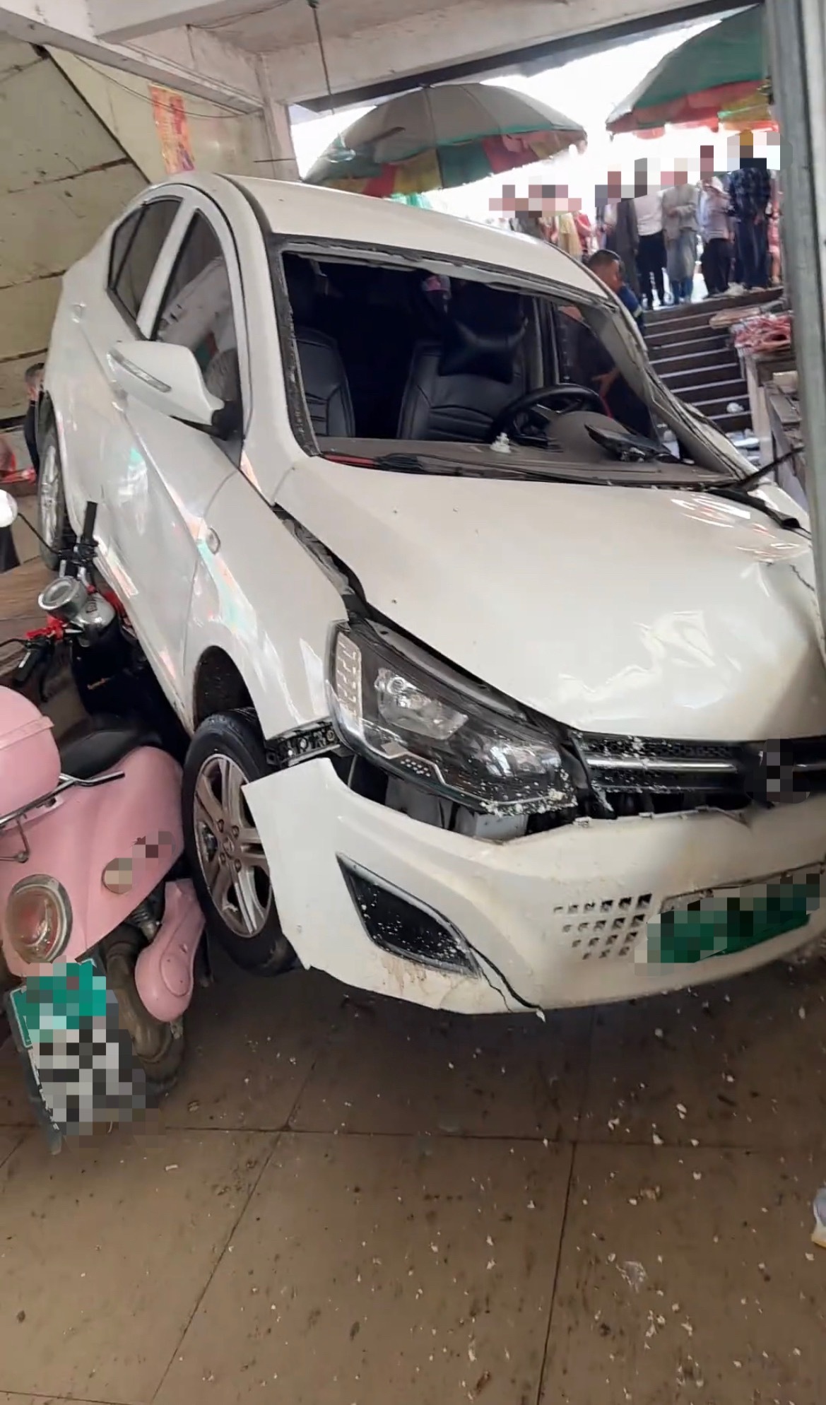 【贵港某丰市场新能源小车冲进猪肉行】4月26日，广西贵港一辆白色的新能源小轿车冲