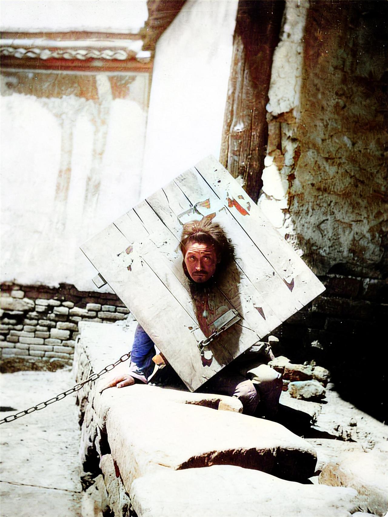 清末时期，一名在街边示众的囚徒，匍匐着身体，正在用犀利的目光注视着拍照的洋人 。