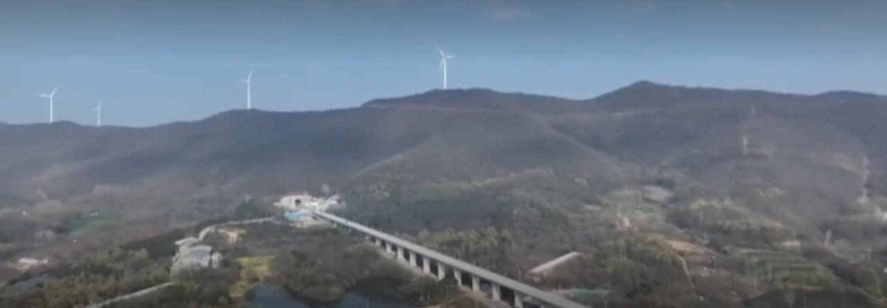 春日的田野上，连片麦苗长势喜人，自动化喷灌设施均匀喷洒水雾，植保无人机穿梭作业。