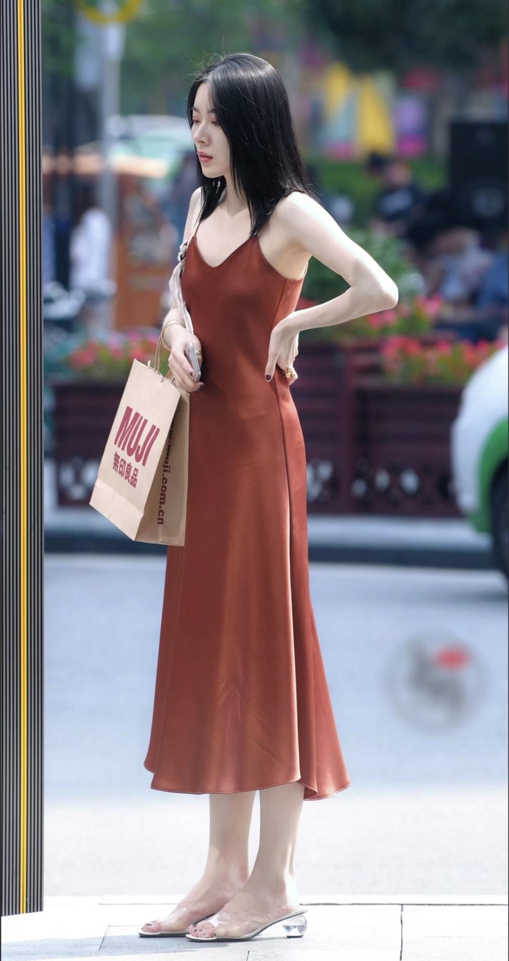 缎面垂落，晕开焦糖色的温柔。
步履轻缓，透明鞋跟接住阳光。
不必刻意张扬。
一身
