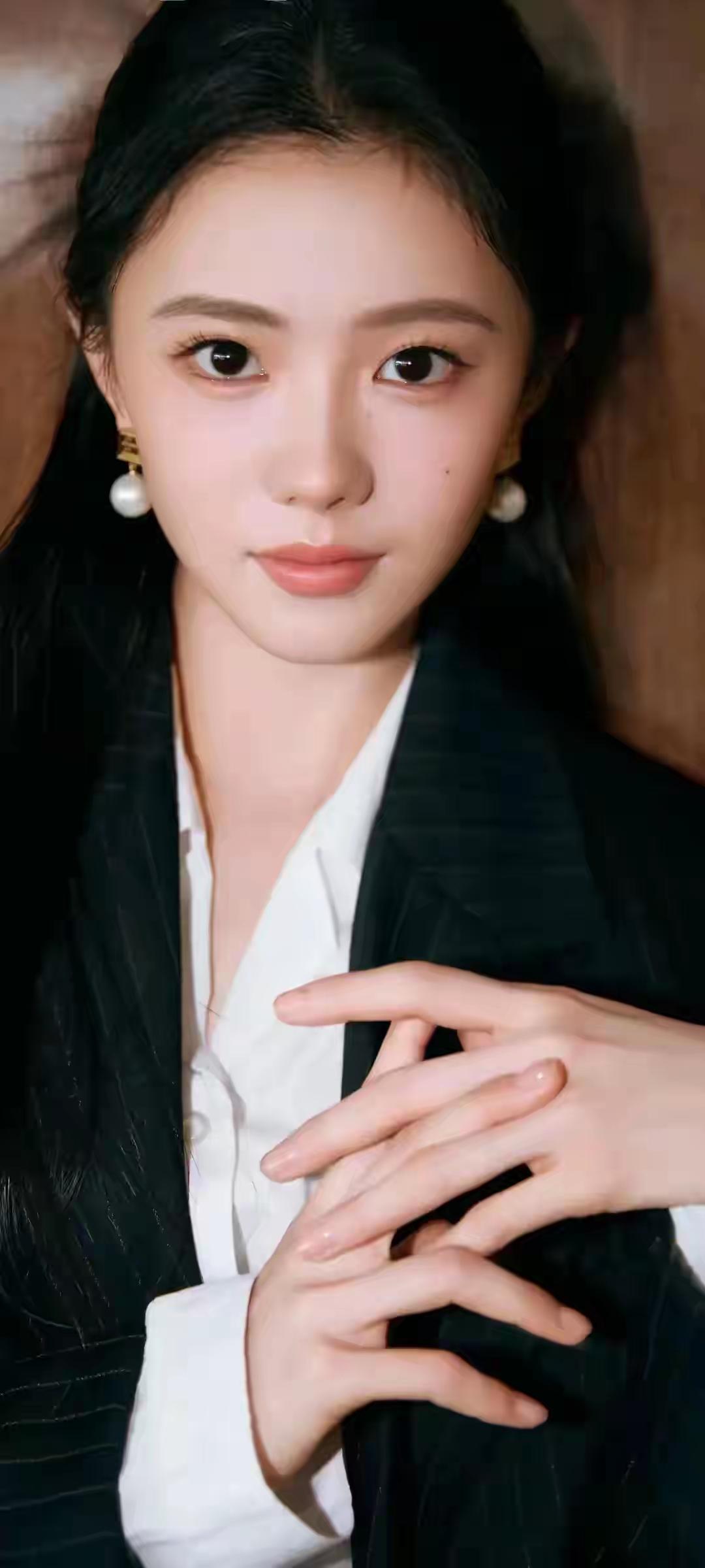 优雅黑发少女，珍珠耳环点缀，黑白西装尽显时尚魅力。