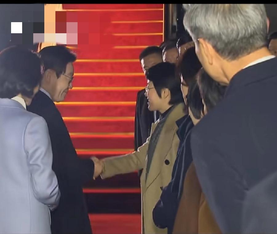 李在明上海机场返程，3个细节:
1、登舷梯前一位女士送了一本访华画册，应该中方人