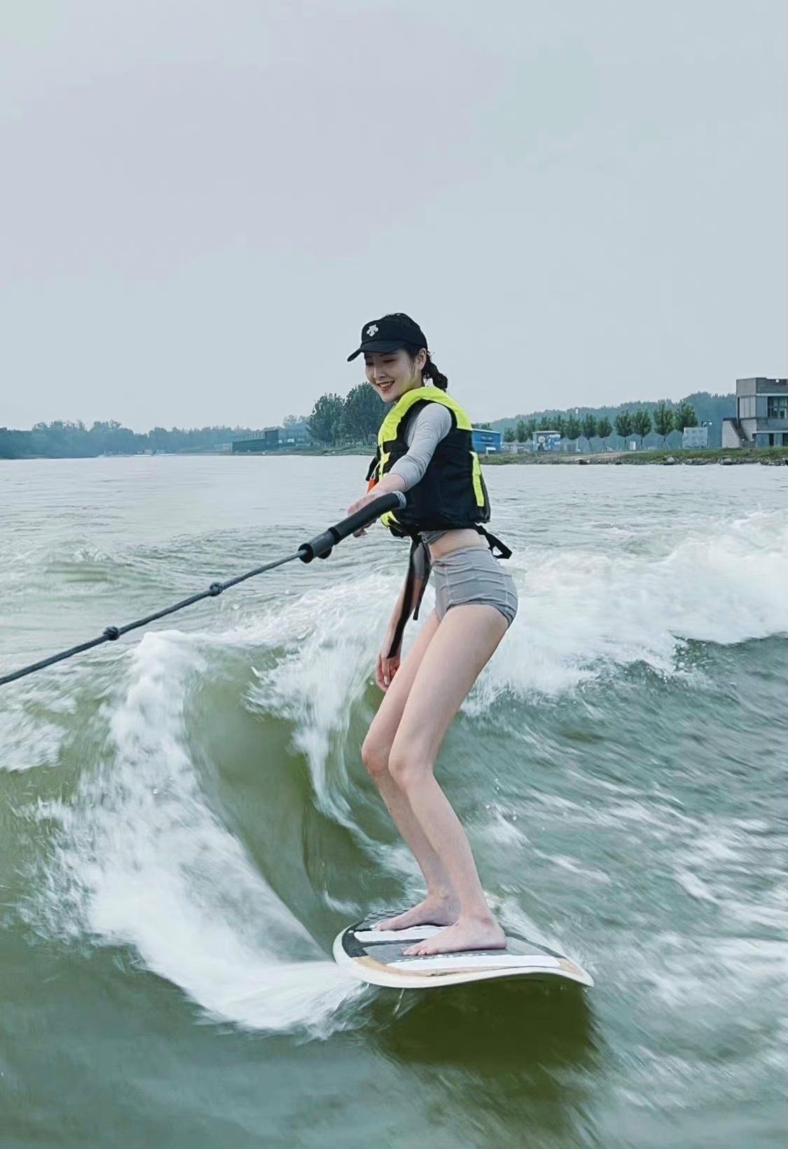 这位正在快乐冲浪的美女，你认识她是谁吗？这极限大长腿目测至少在1米2以上吧。

